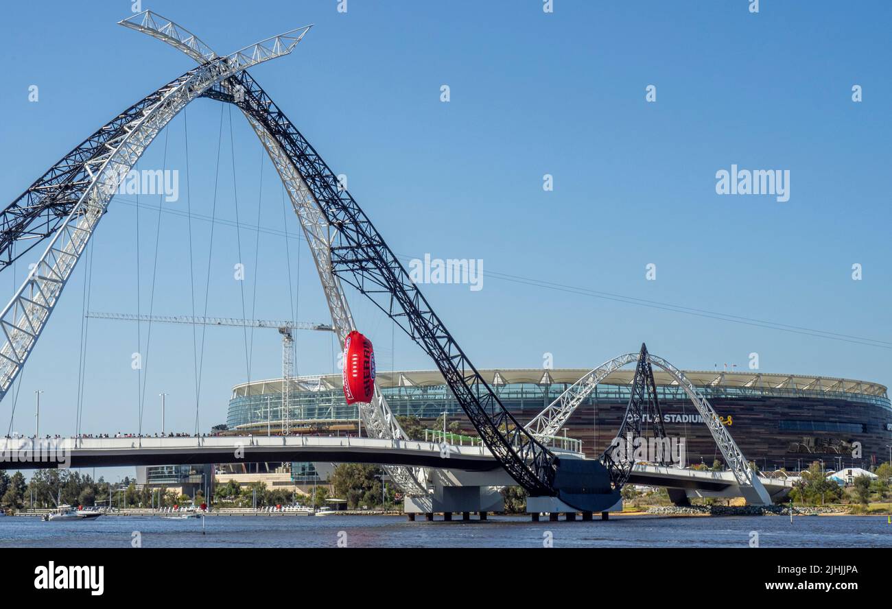 Des spectateurs traversent le pont Matagarup avec un ballon de football gonflable suspendu pour assister à la grande finale de l'AFL 2021 au stade Otpus de Perth, en Australie occidentale. Banque D'Images