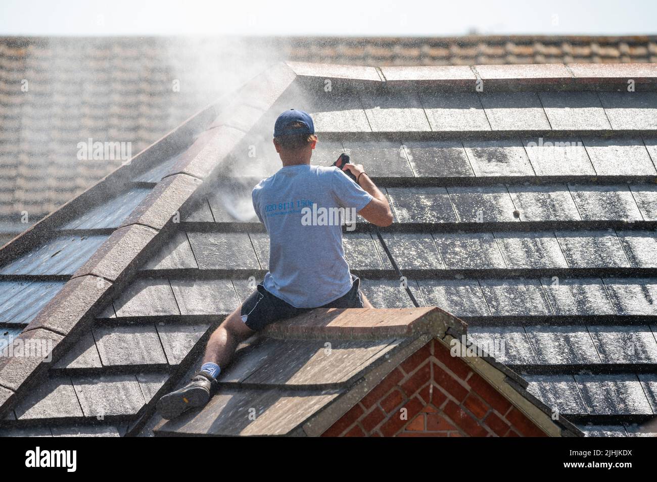 Rustington, West Sussex, Royaume-Uni. Mardi 19th juillet 2022. Un homme utilise un jet-wash pour nettoyer le toit d'une maison ce matin alors que la chaleur continue à s'apaiser, près de la côte sud. Crédit : Geoff Smith/Alamy Live News Banque D'Images