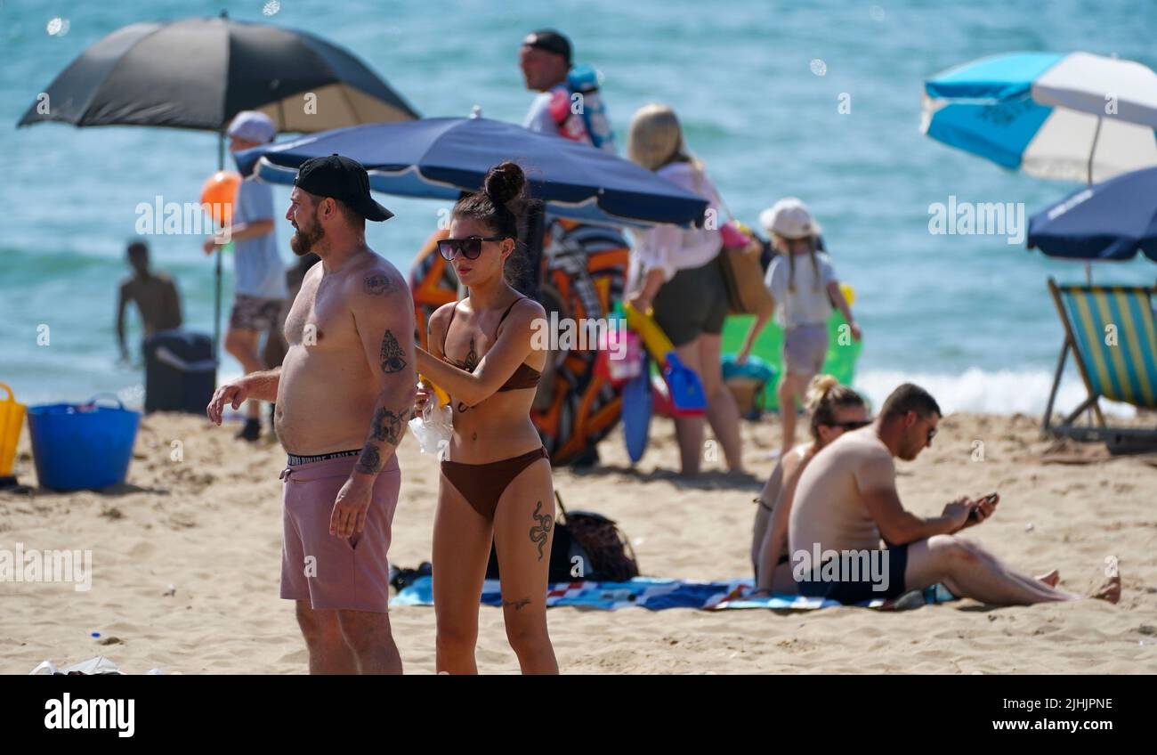 Les gens appliquent de la crème solaire sur la plage de Bournemouth. Les Britanniques sont sur le point de fondre le jour le plus chaud jamais enregistré au Royaume-Uni alors que les températures devraient atteindre 40C. Date de la photo: Mardi 19 juillet 2022. Banque D'Images