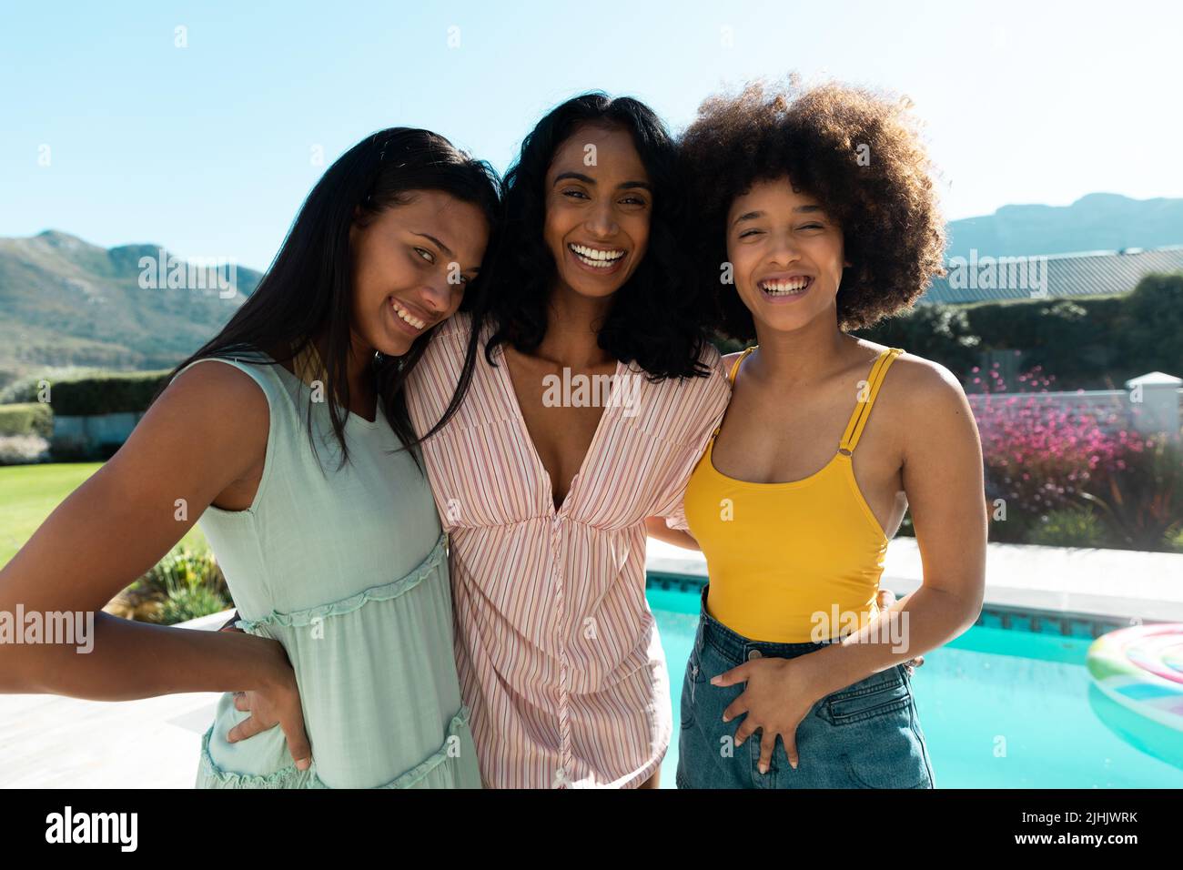 Portrait de jeunes amis biraciaux joyeux appréciant le temps libre ensemble contre le ciel clair en été Banque D'Images