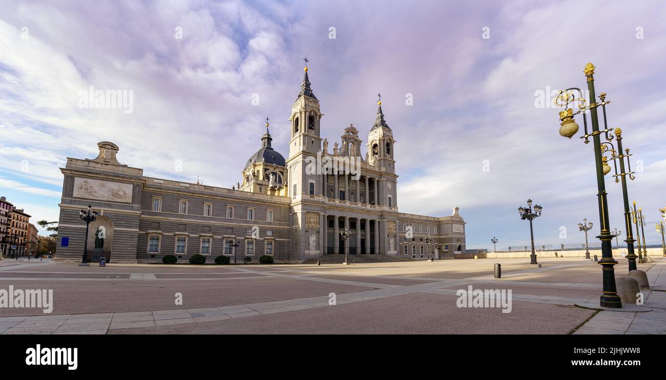 Cathédrale d'Almudena à Madrid et son immense esplanade en face avec des lampadaires et un ciel bleu. Espagne. Banque D'Images