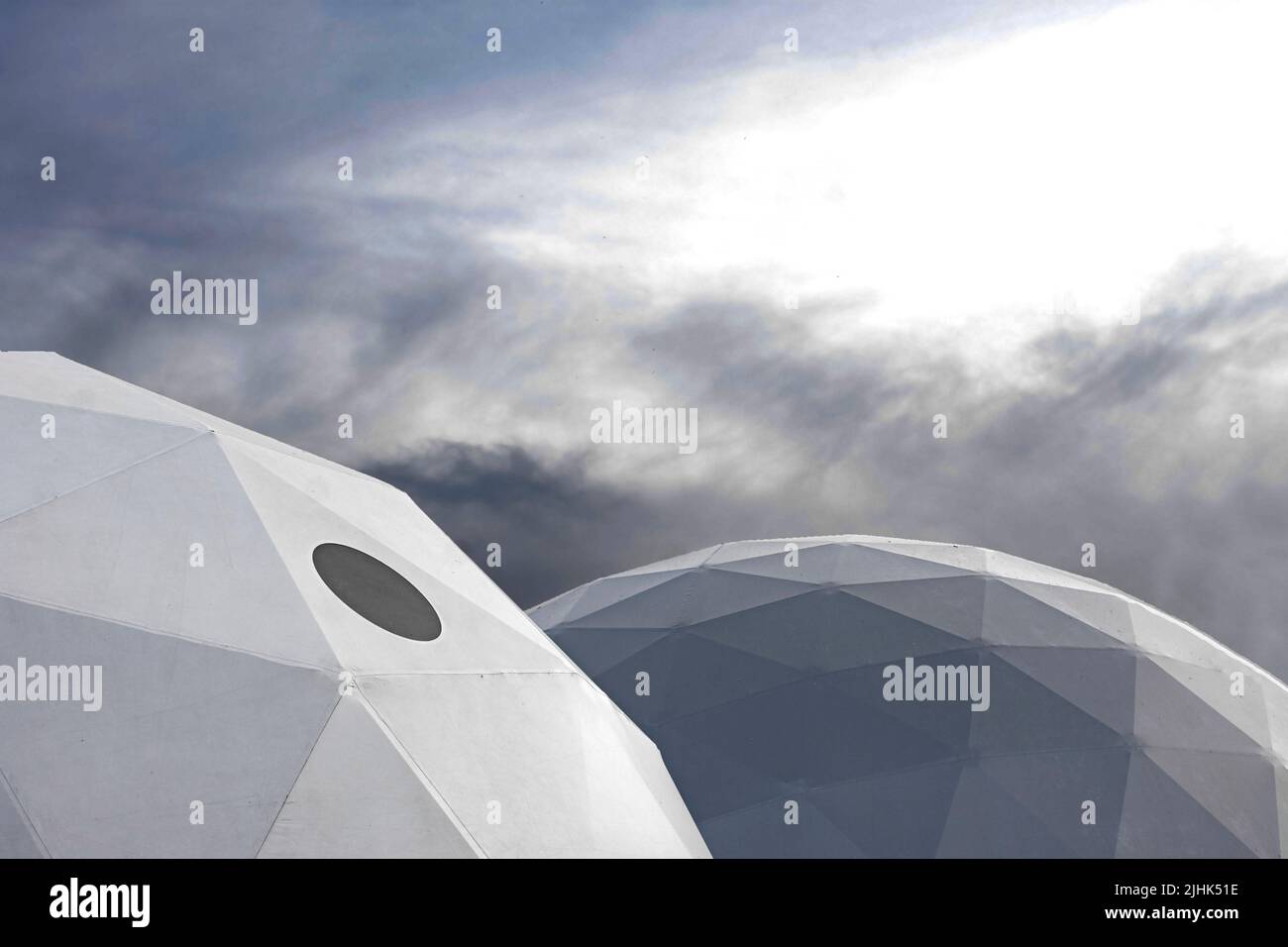 Deux structures ovales de forme triangulaire avec fenêtre noire entourée de nuages sombres ressemblant à un centre d'exploration spatiale Banque D'Images