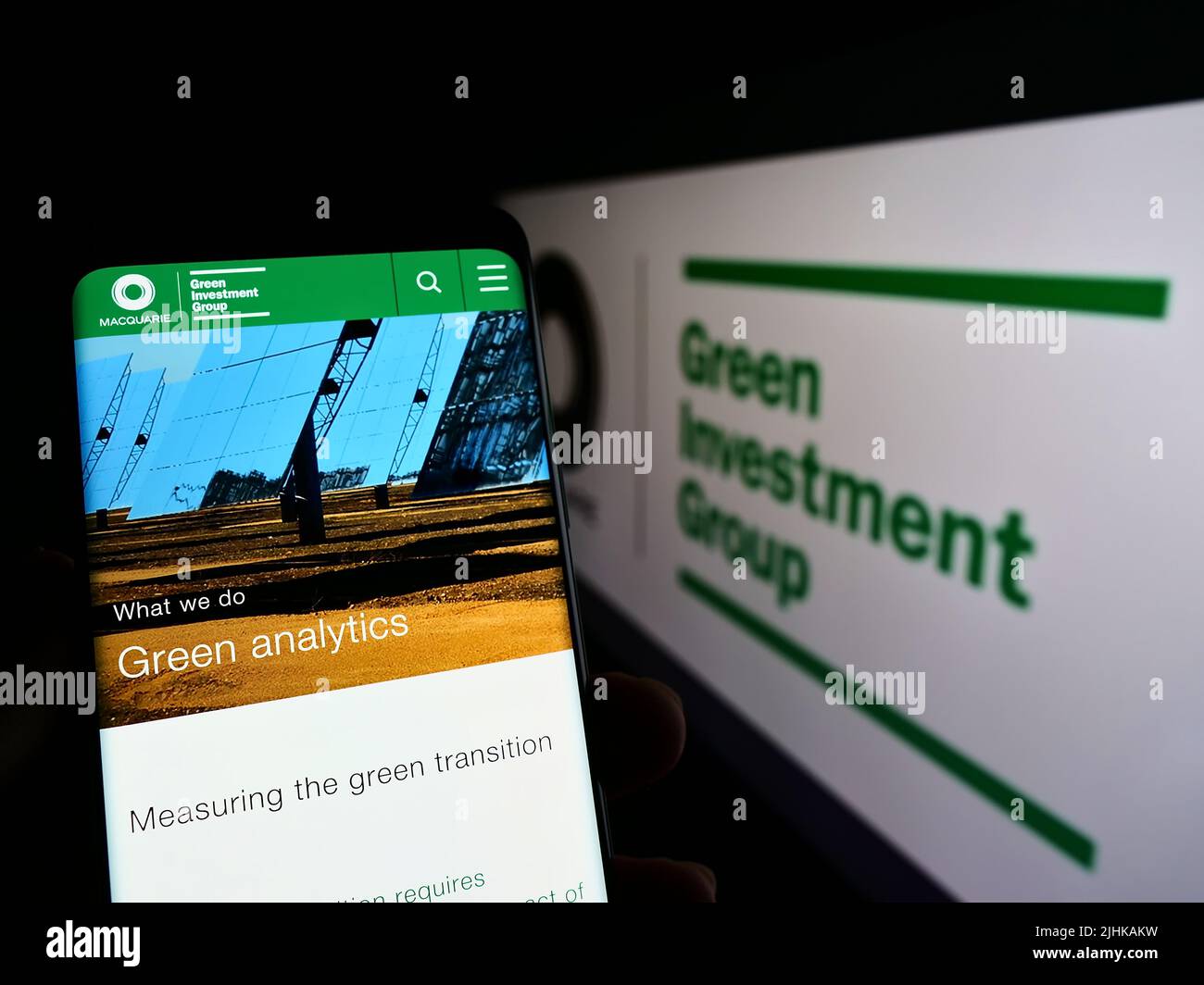 Personne tenant un téléphone cellulaire avec la page Web de la société Green Investment Group Limited (GIG) à l'écran avec logo. Concentrez-vous sur le centre de l'écran du téléphone. Banque D'Images