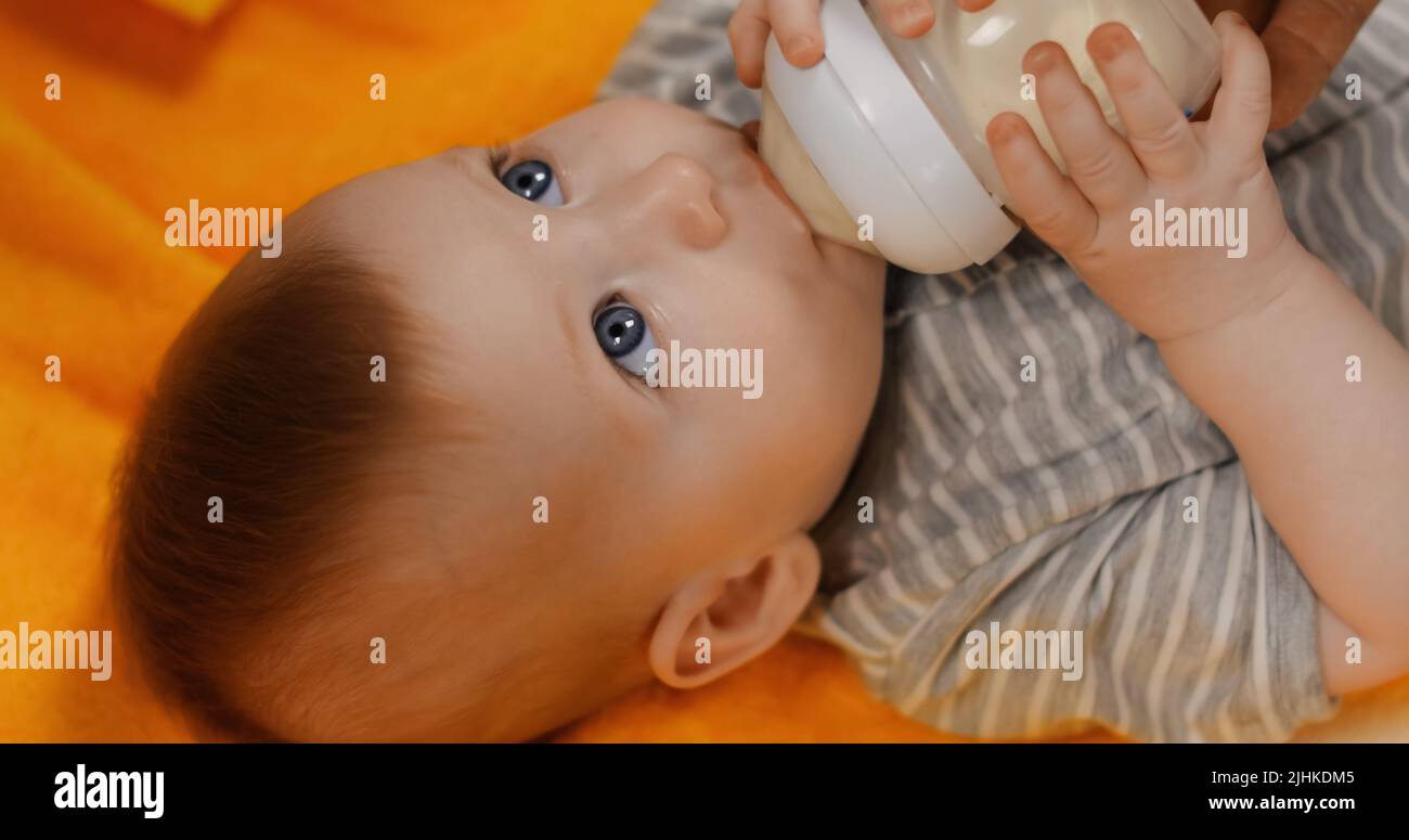 vue en grand angle du bébé garçon qui boit du lait provenant du biberon Banque D'Images