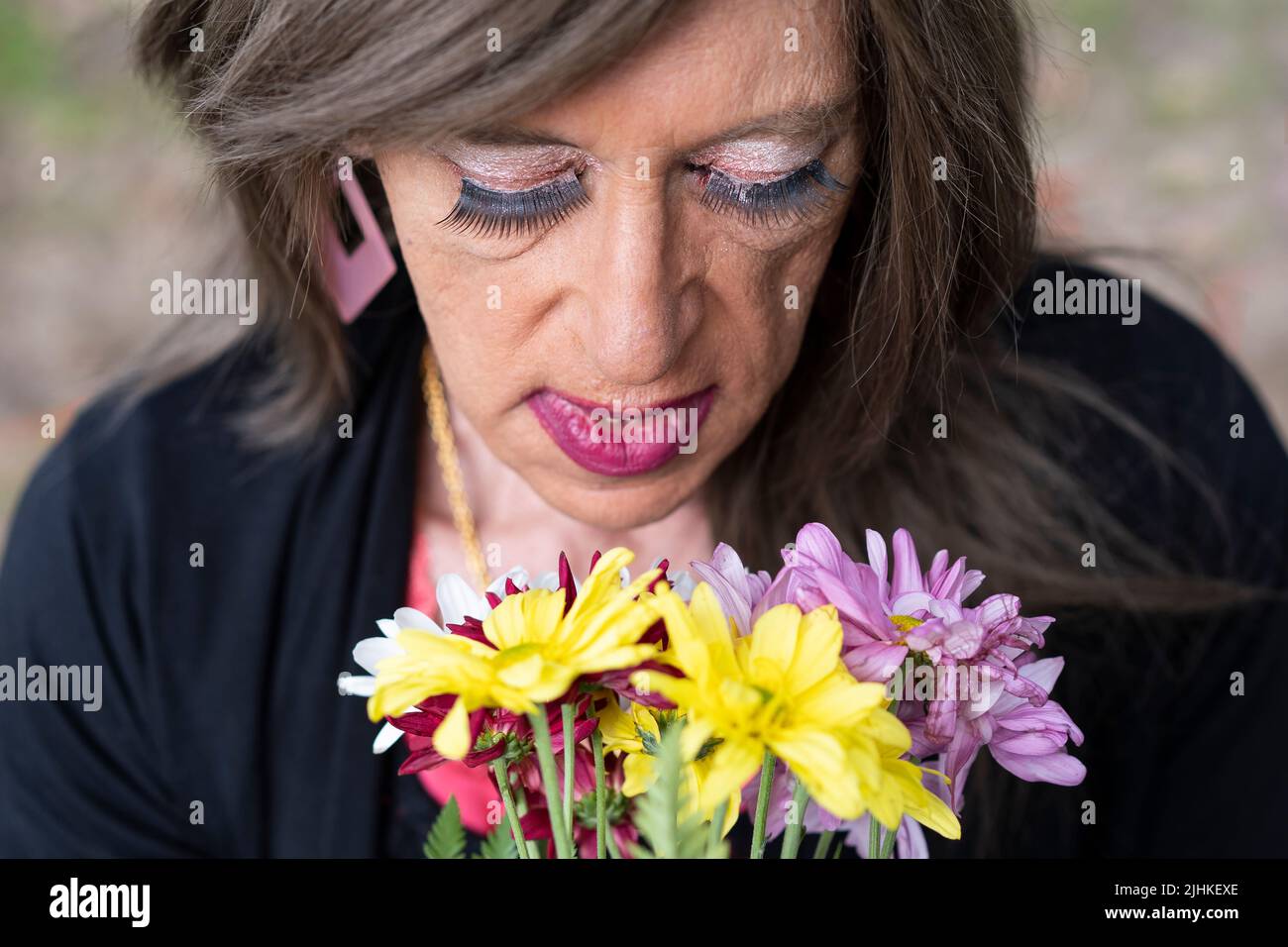 Vue de dessus portrait d'une femme transgenre mûre avec un bouquet de fleurs Banque D'Images