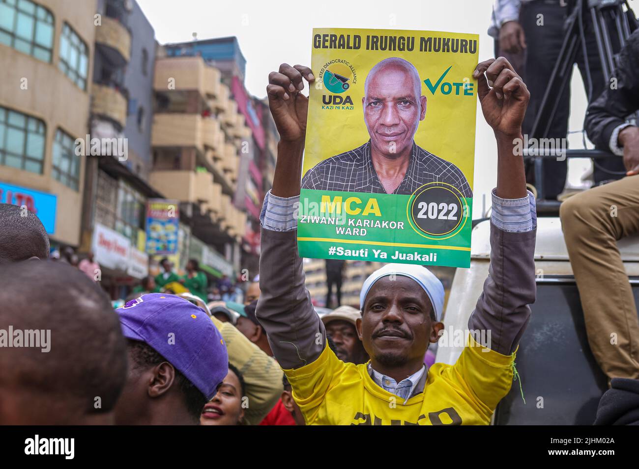 Un Kenyan est titulaire d'une affiche de l'un des membres de l'Assemblée du comté (MCA), qui se présente au poste électif lors d'un rassemblement de campagne du vice-président du Kenya et du candidat présidentiel de l'Alliance démocratique unie (UDA) William Ruto sur le marché de Gikomba à Nairobi. William Ruto est tireur pour la présidence sur un billet de l'Alliance démocratique unie (UDA) avant les élections générales du 9th août 2022 au Kenya. Il affrontera 3 autres candidats parmi lesquels l'ancien Premier ministre du Kenya et le candidat à la présidence d'Azimio la Umoja, Raila Odinga. Ruto a visité le marché de Gikomba Banque D'Images