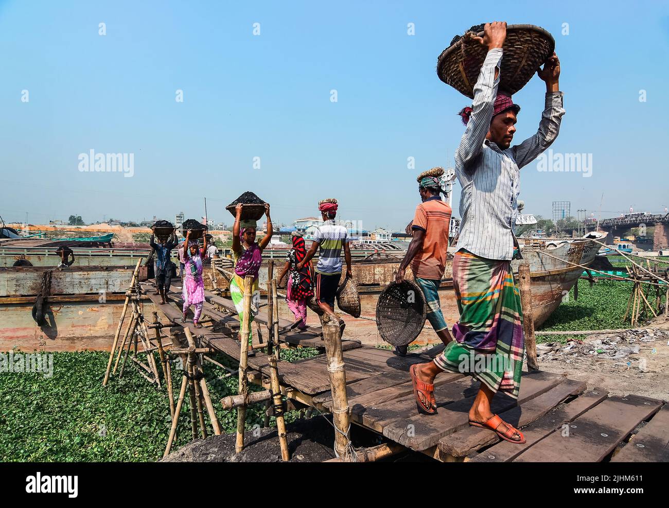 Les travailleuses transportant des paniers remplis de charbon sur leur tête dans la région de Gabtoli à Dhaka Banque D'Images