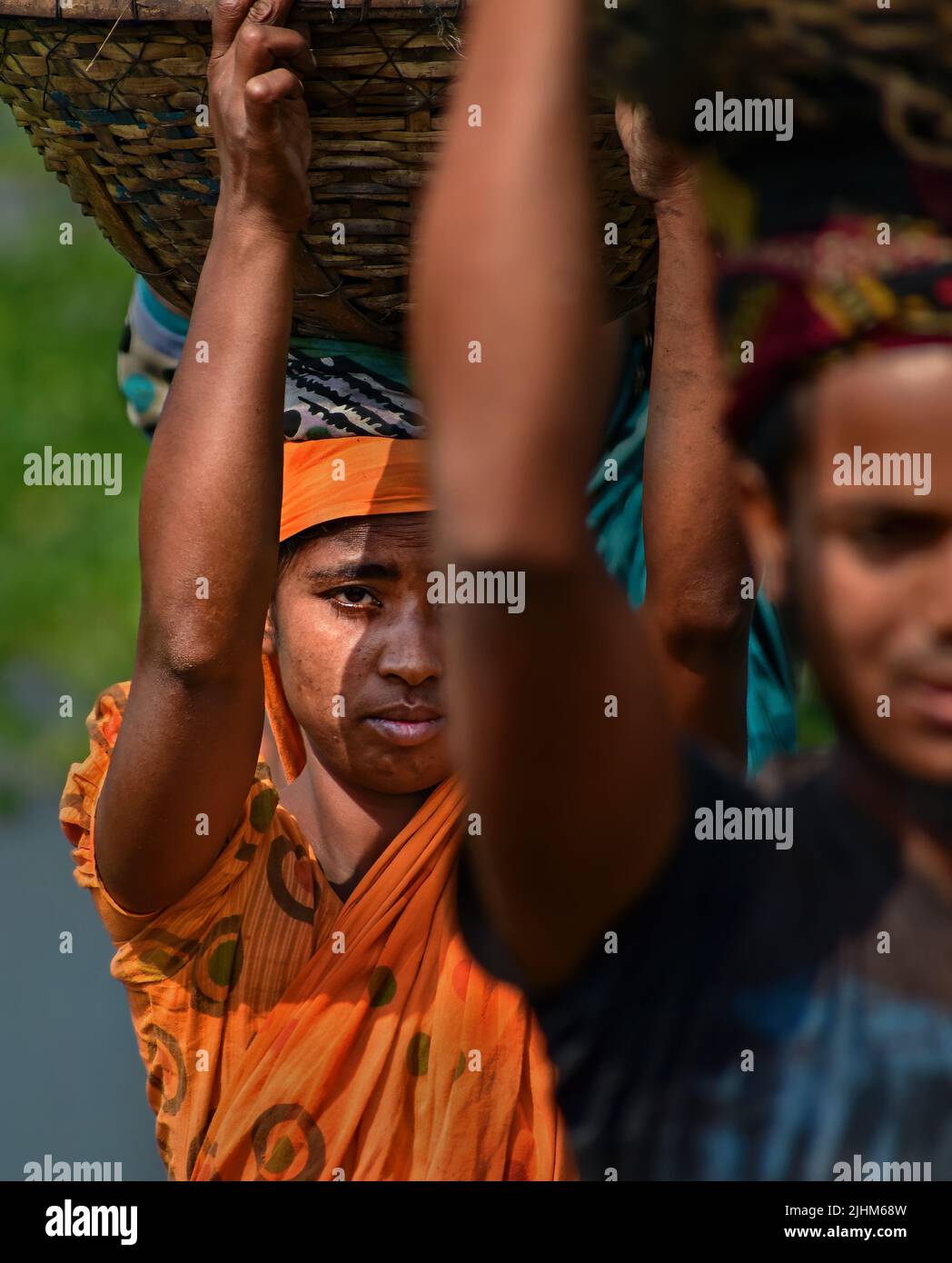 Les travailleuses transportant des paniers remplis de charbon sur leur tête dans la région de Gabtoli à Dhaka Banque D'Images