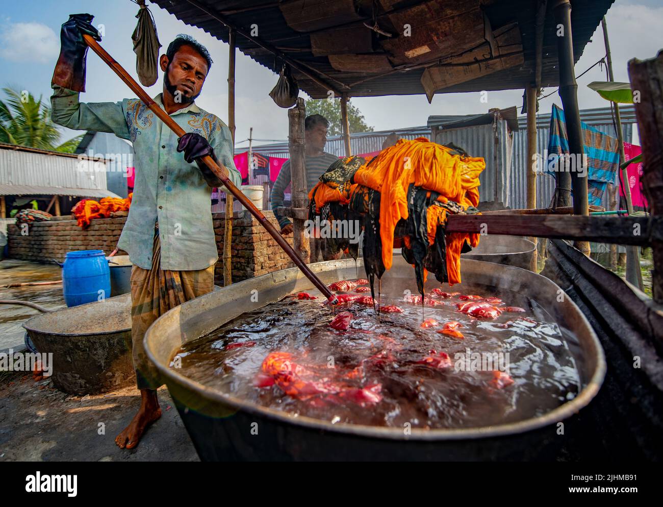 Fils et tissus colorés teints et séchant dans les champs ouverts. Textile, vêtements, mode, teinture de tissu, fait à la main, procédé de séchage, artisanat rural Banque D'Images