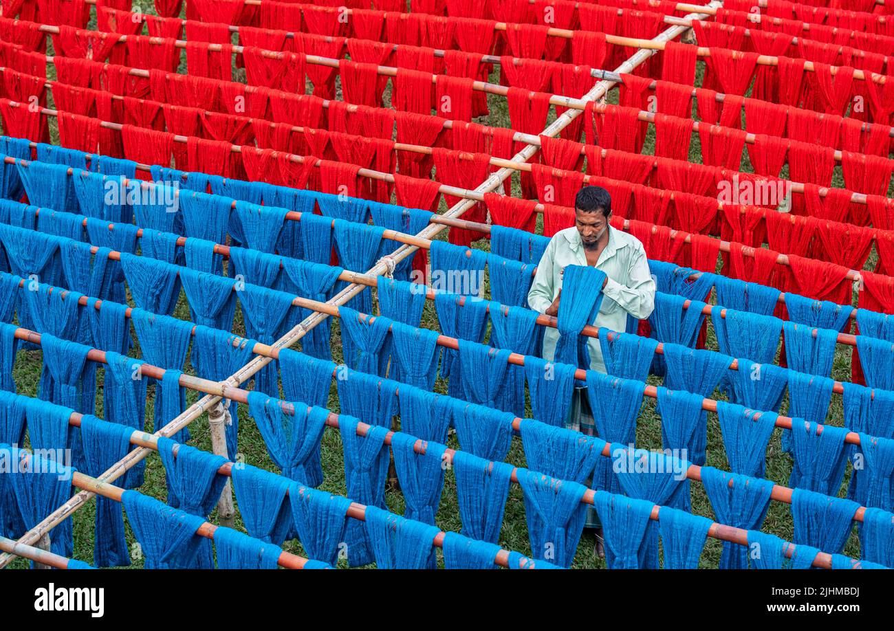 Fils et tissus colorés teints et séchant dans les champs ouverts. Textile, vêtements, mode, teinture de tissu, fait à la main, procédé de séchage, artisanat rural Banque D'Images