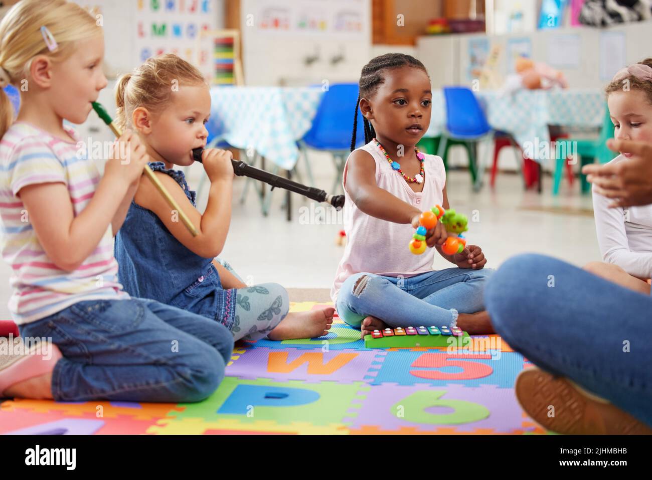 Laissez-les jouer librement et explorer les sons. Les enfants apprennent sur les instruments de musique en classe. Banque D'Images