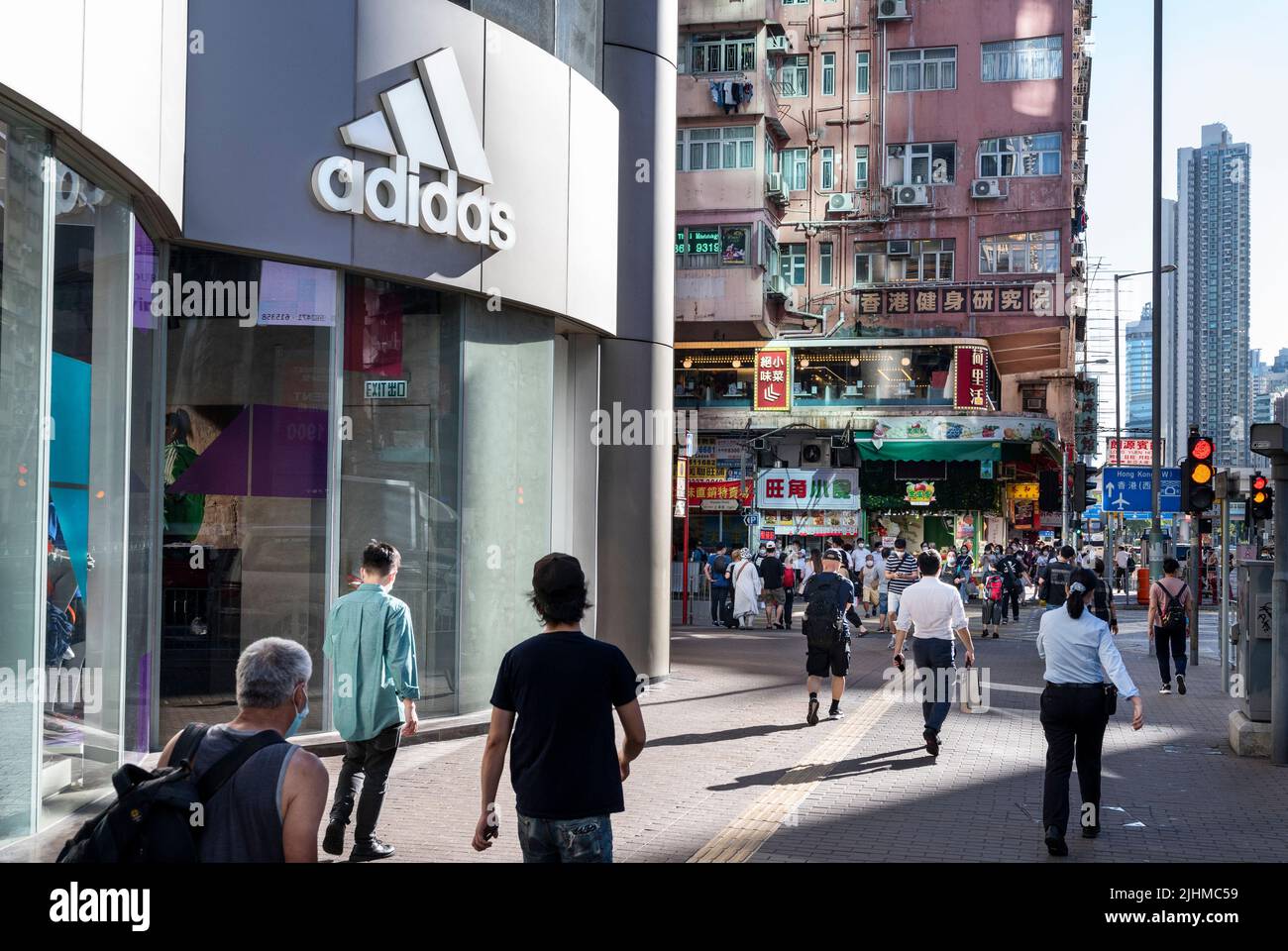 Des piétons marchent devant le magasin Adidas de la marque multinationale allemande de vêtements de sport à Hong Kong. Banque D'Images