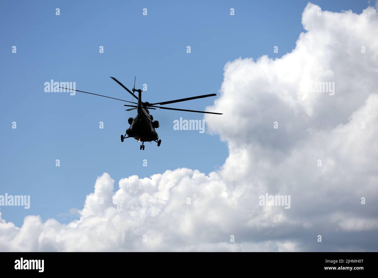 Silhouette de l'hélicoptère militaire mi-8 (codification OTAN : HIP) en vol sur fond de ciel bleu et de nuages blancs Banque D'Images