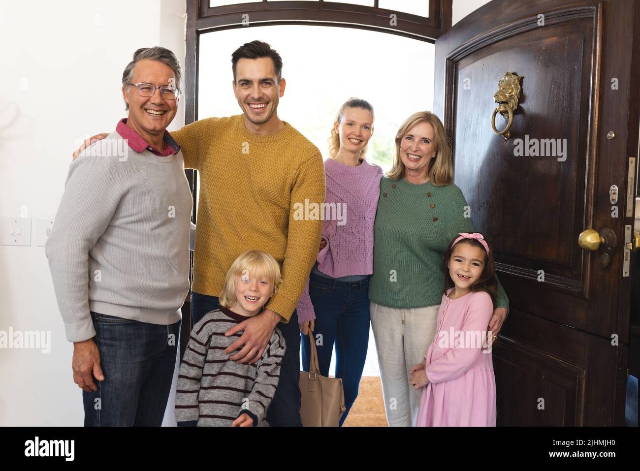 Image d'une famille de caucasiens de plusieurs générations heureux debout à la porte Banque D'Images