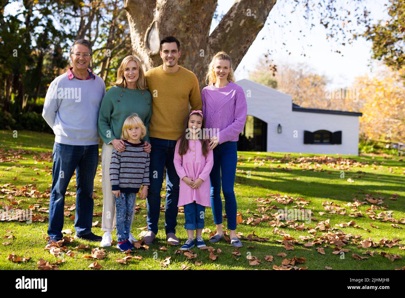 Image d'une famille de caucasiens de plusieurs générations heureuse posant dans un jardin d'automne Banque D'Images