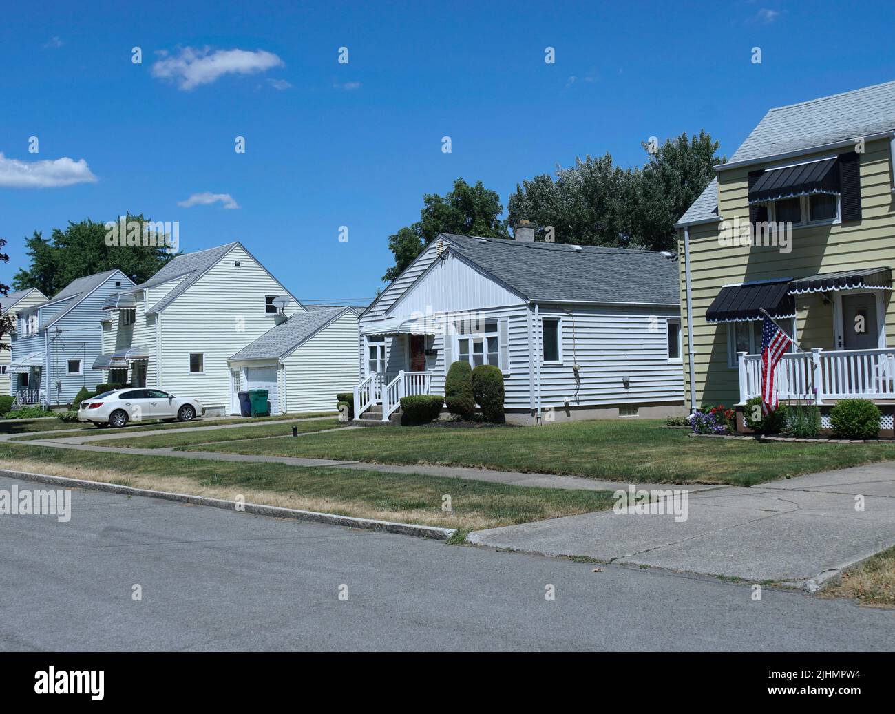 Rue résidentielle suburbaine américaine avec de modestes maisons en panneaux de clopboard Banque D'Images