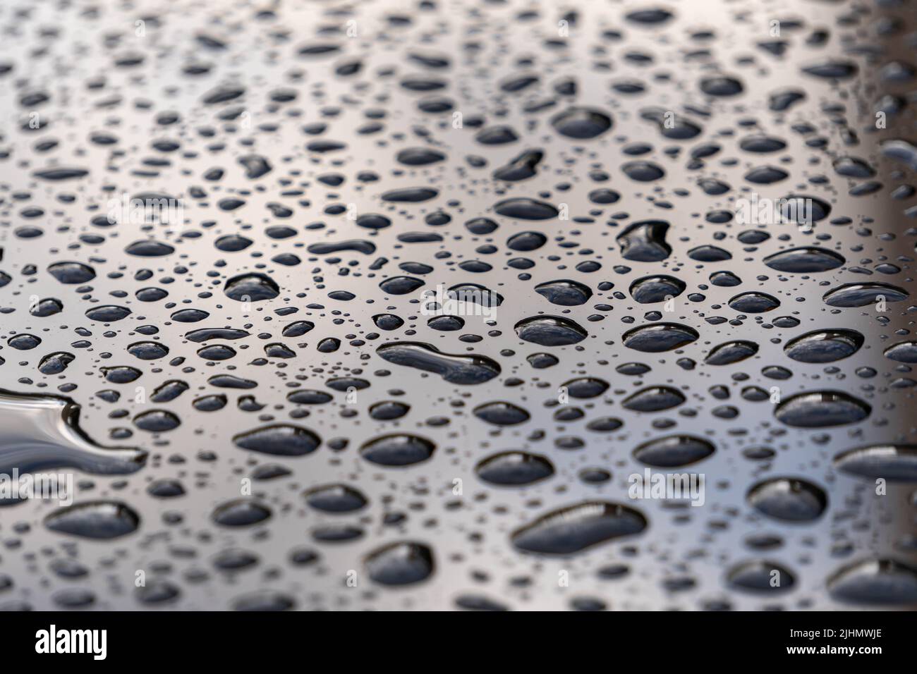 de l'eau tombe sur une surface en verre noir Banque D'Images