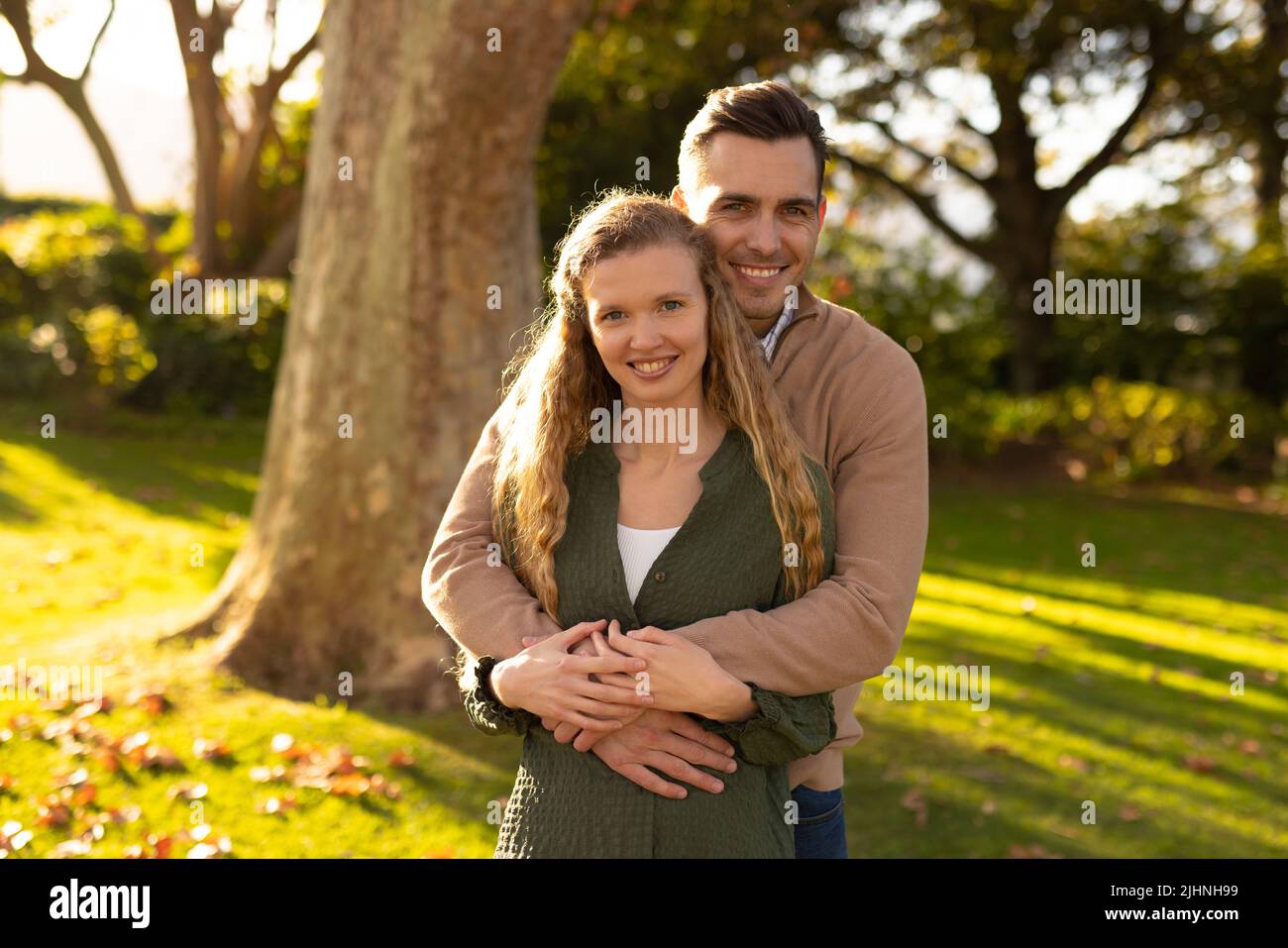 Image d'un couple caucasien heureux posant à la caméra dans le jardin Banque D'Images