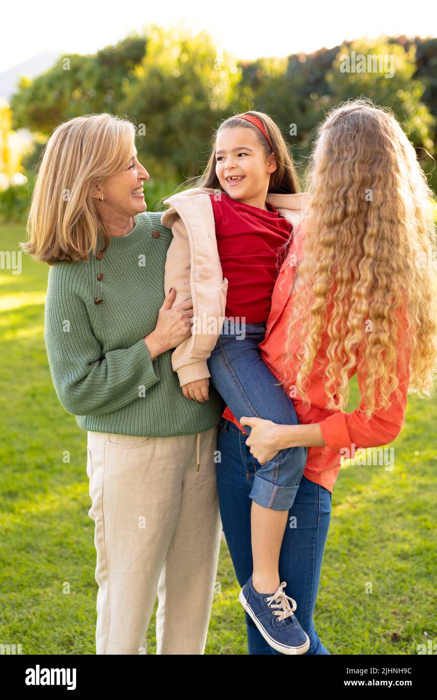 Image verticale des femmes blanches de trois générations heureuses dans le jardin Banque D'Images