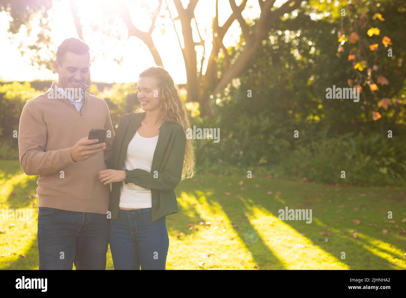 Image d'un couple caucasien heureux prenant le selfie dans le jardin Banque D'Images