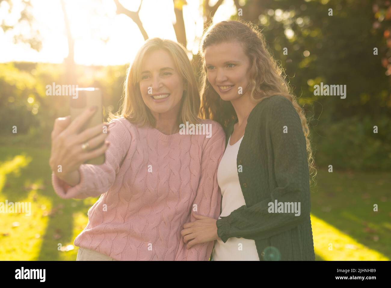 Image de la bonne mère caucasienne et de la fille adulte prenant le selfie dans le jardin d'automne Banque D'Images