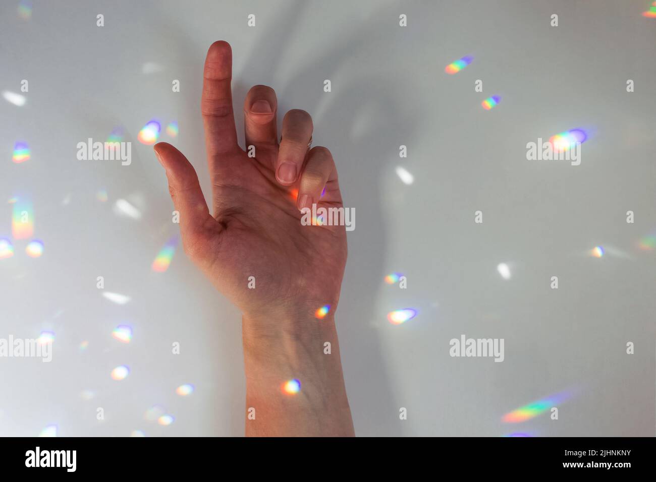 Geste de la main de la femme et réflexion de lumière à prisme Banque D'Images