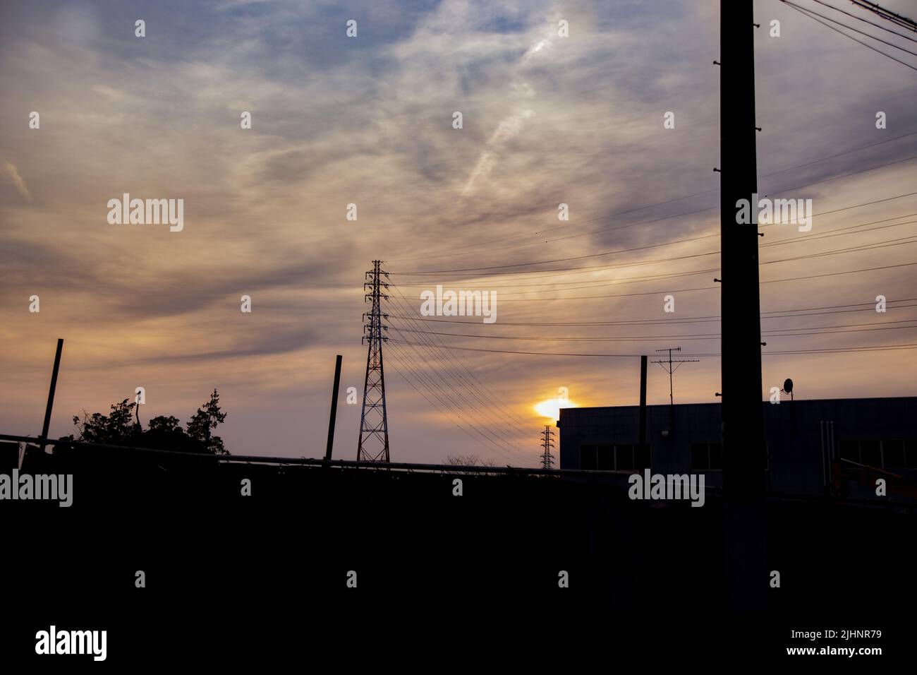 Silhouette de câbles électriques et de tours au coucher du soleil Banque D'Images