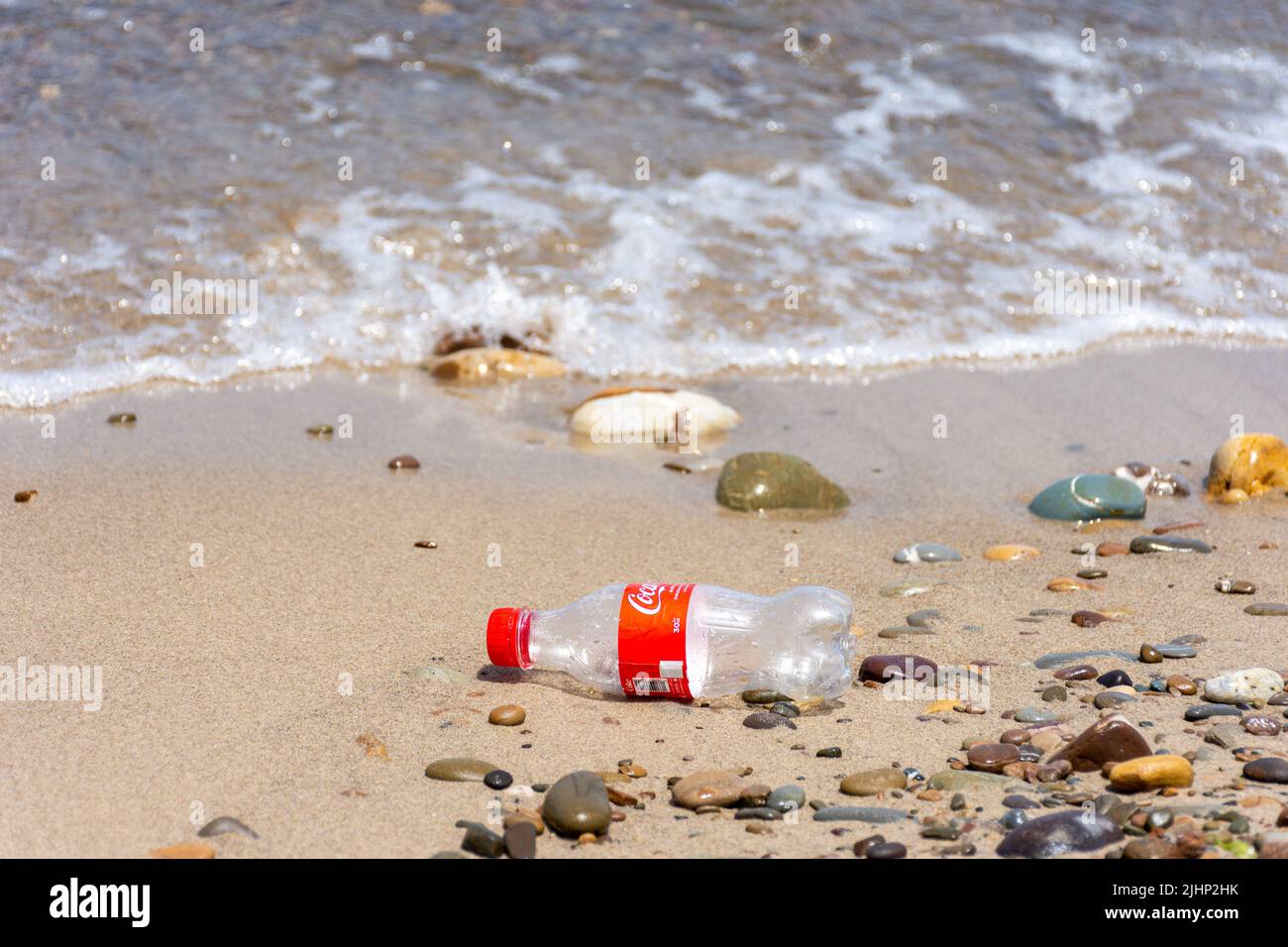 Vue sur une bouteille en plastique sur une plage de galets. Concept Save Earth. Banque D'Images