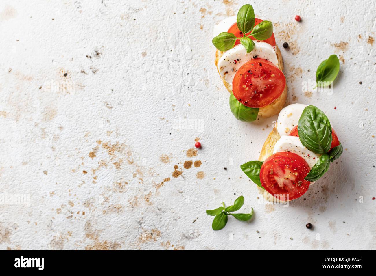 Bruschetta végétarienne avec mozzarella, tomates et basilic sur un fond texturé, vue de dessus avec espace de texte. Concept de saine alimentation, antipa Banque D'Images