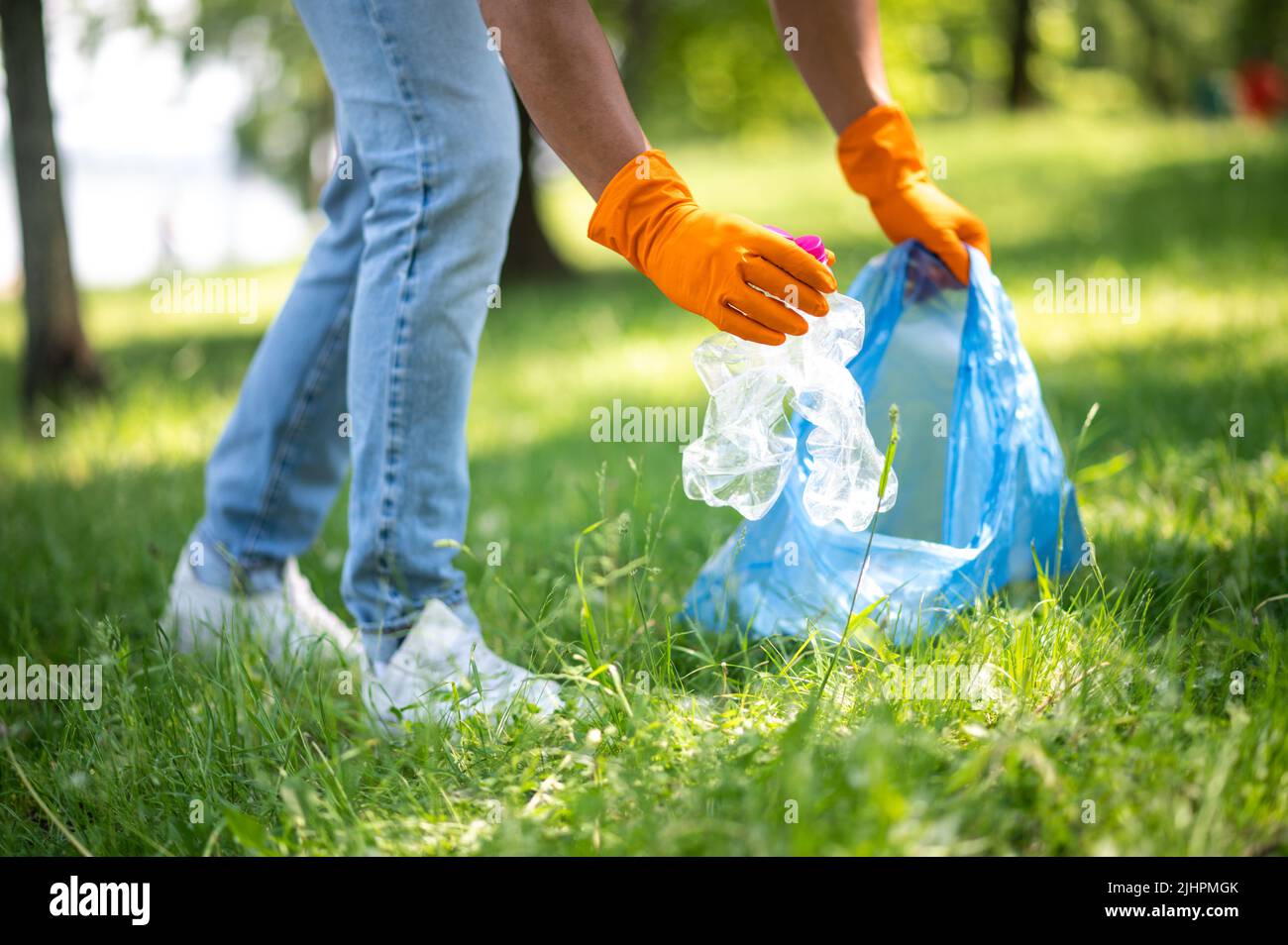 Les mains du Mans ramassent les déchets de l'herbe Banque D'Images