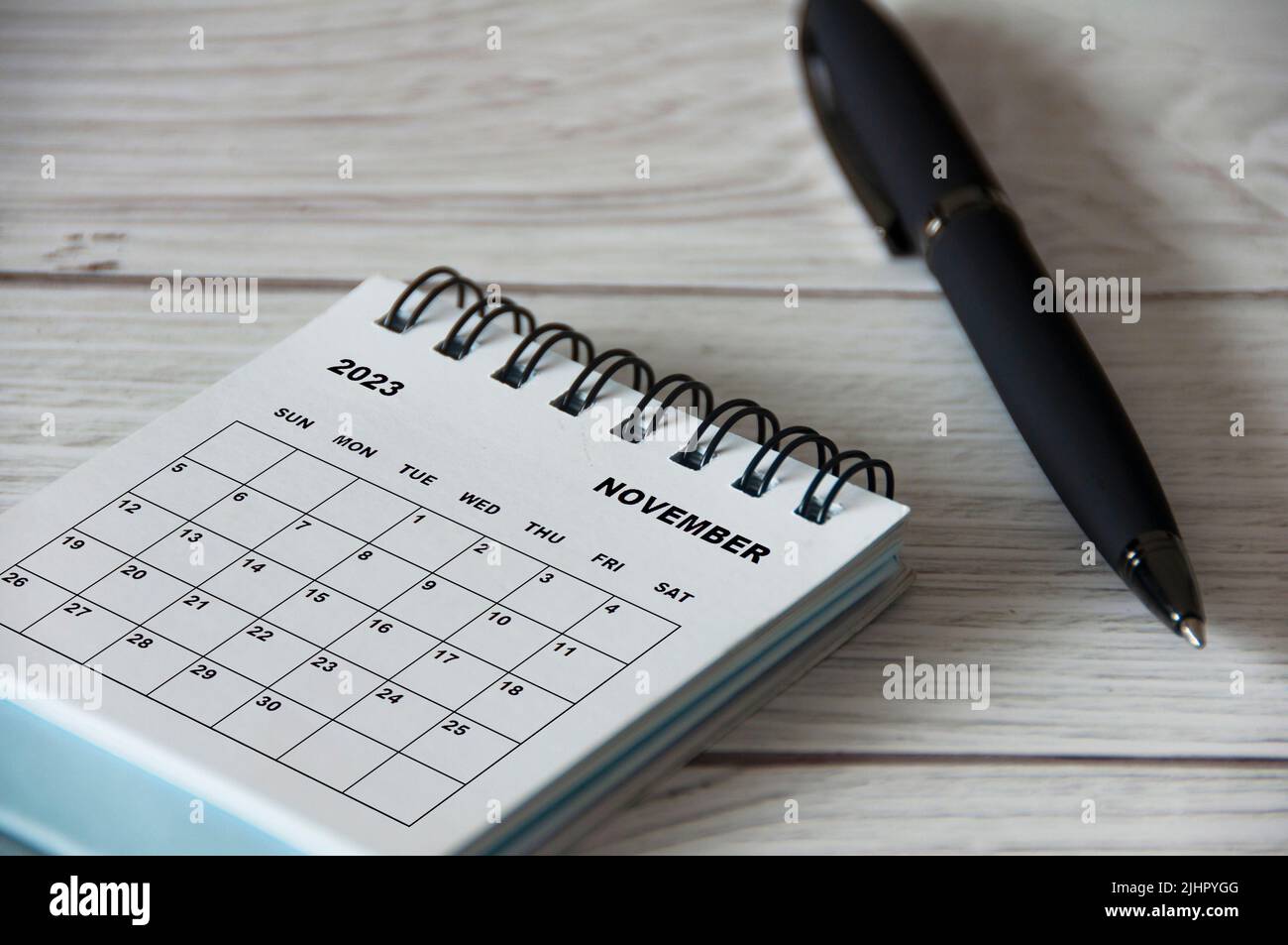 Calendrier de bureau blanc de novembre 2023 avec stylo noir sur table en bois. Concept de calendrier Banque D'Images
