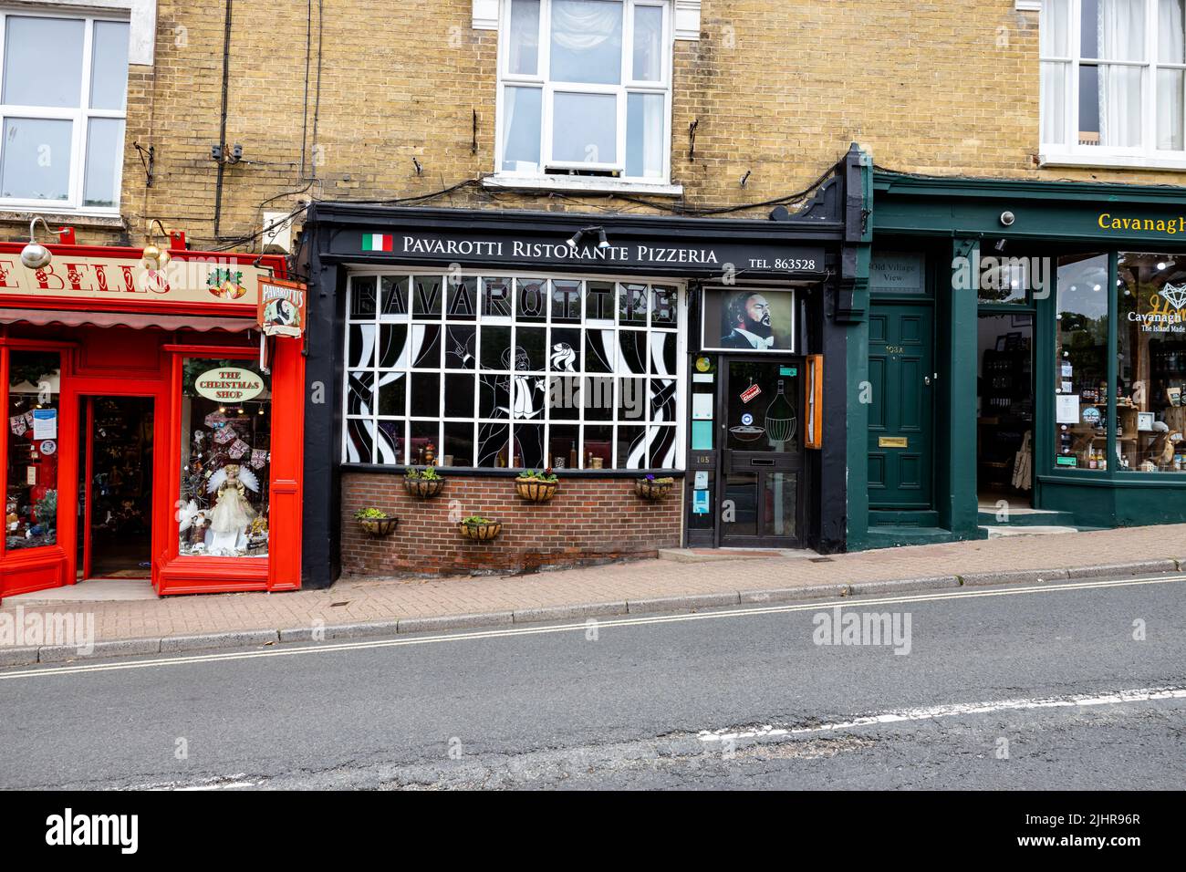 Vue extérieure du restaurant italien Pavarotti et de la pizzeria avec vitraux et paniers muraux fleuris Banque D'Images