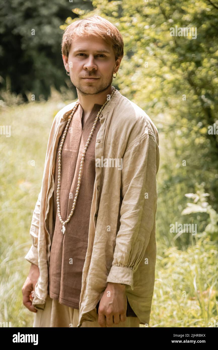 Portrait de l'homme en chemise de lin debout en forêt Banque D'Images