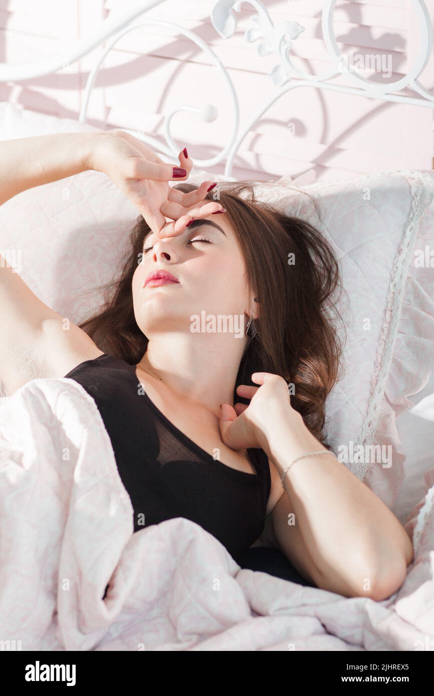 Portrait d'une femme qui se réveille dans son lit Banque D'Images