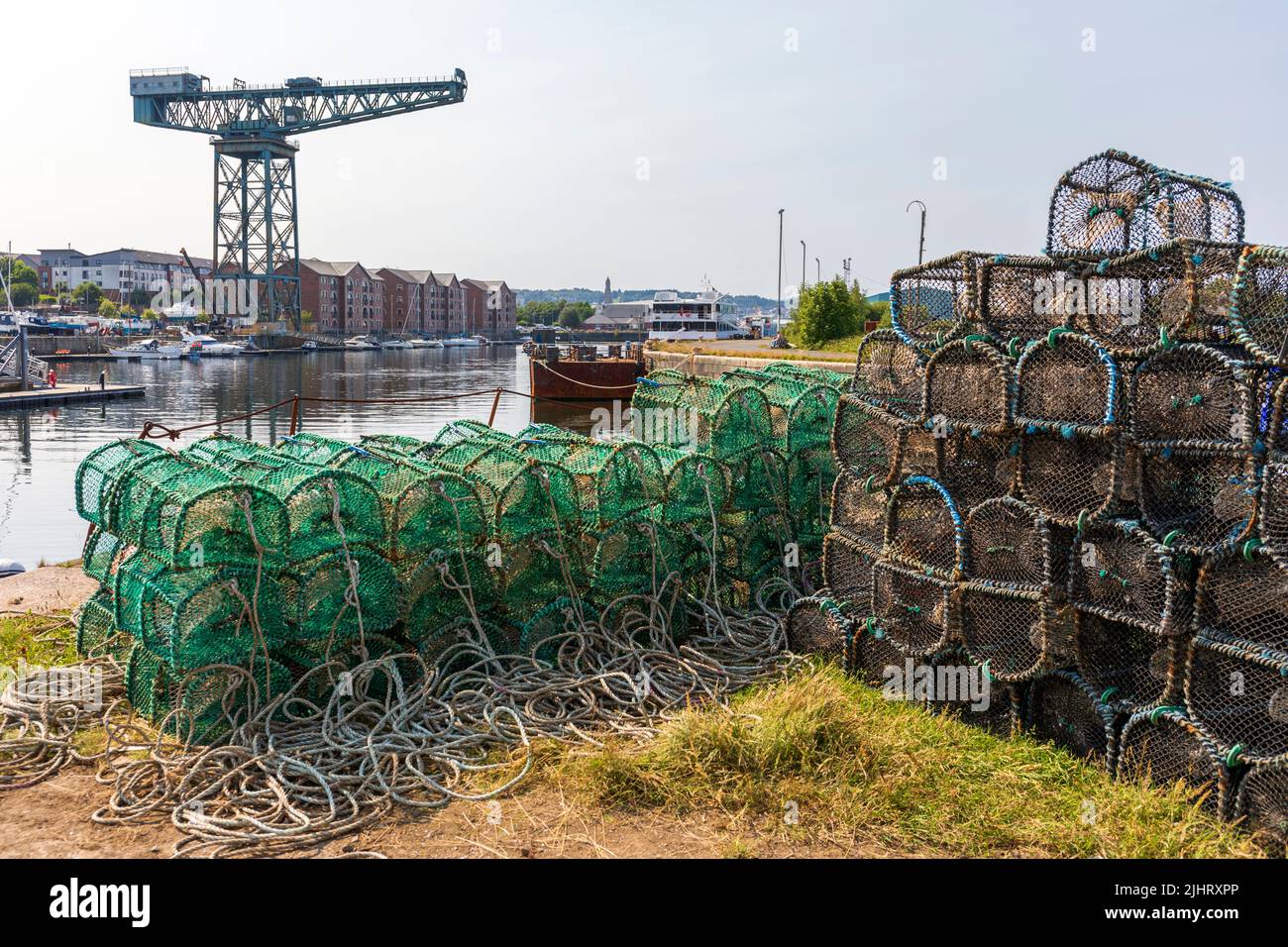 Pots de homard à la marina de James Watt, avec des yachts à quai et la grue de chantier naval en porte-à-faux au loin, Port Glasgow, Inverclyde, Écosse, Royaume-Uni Banque D'Images