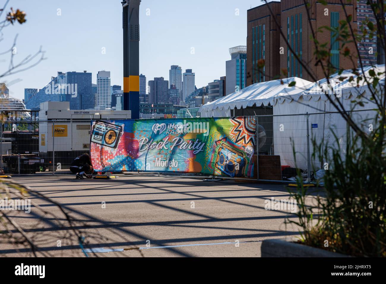 Un homme mettant un panneau iHeart radio Block Party à l'embarcadère 76 de Manhattan, New York Banque D'Images