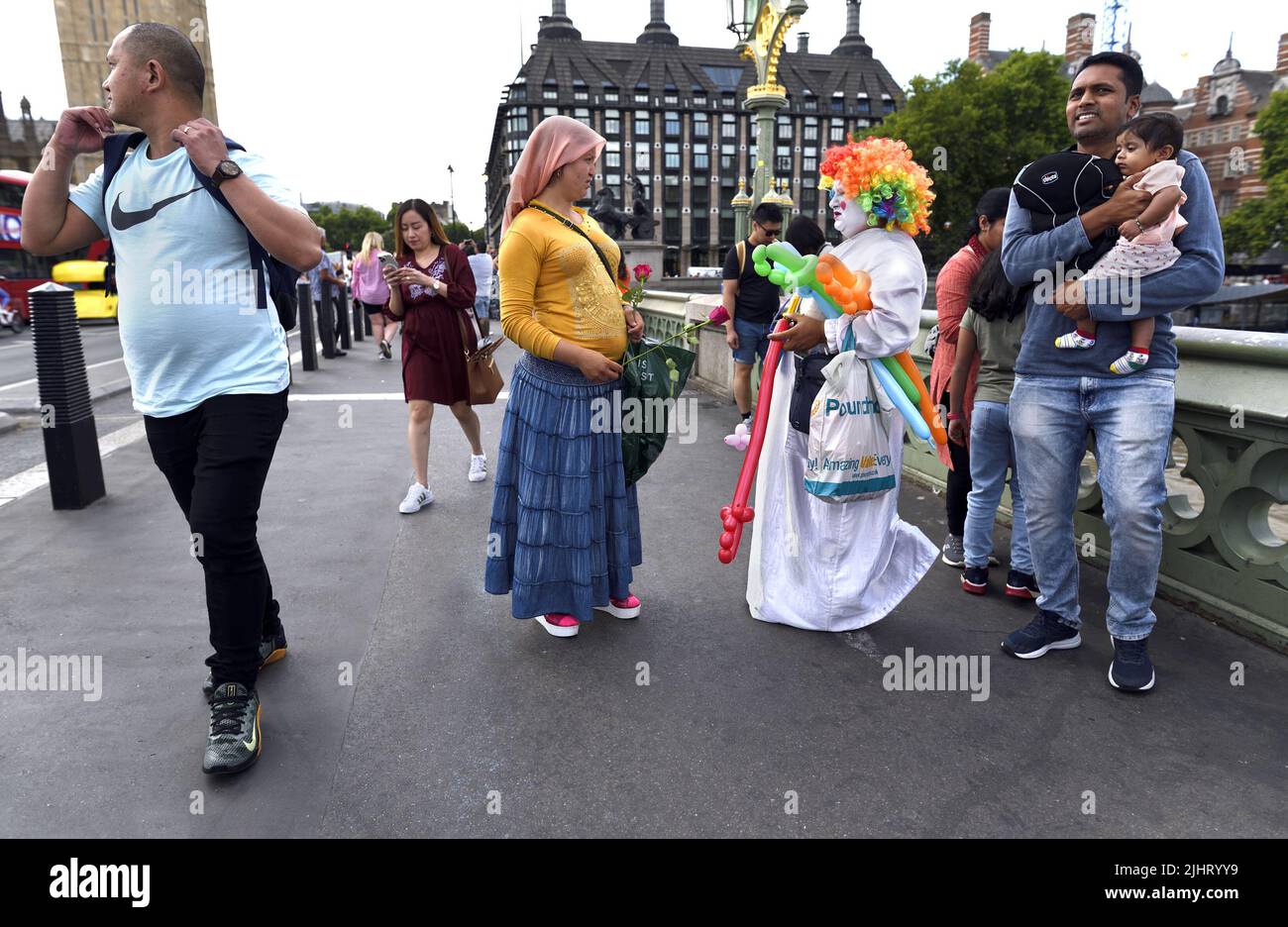 Londres, Angleterre, Royaume-Uni. Le vendeur de ballons coloré parle à un pourvoyeur de roses sur le pont de Westminster, juillet 2022 Banque D'Images