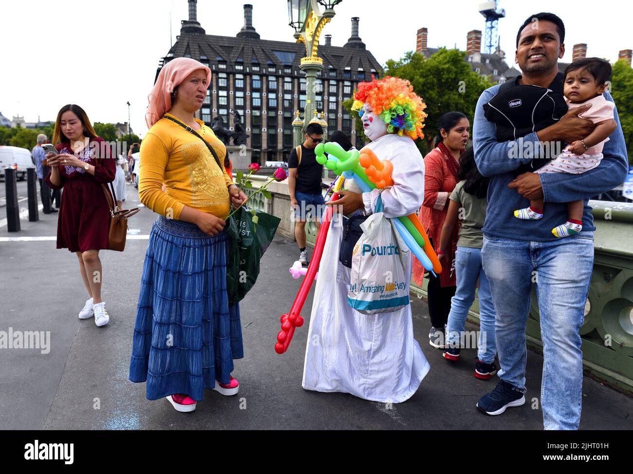 Londres, Angleterre, Royaume-Uni. Le vendeur de ballons coloré parle à un pourvoyeur de roses sur le pont de Westminster, juillet 2022 Banque D'Images
