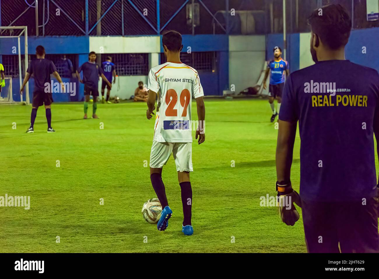 Kolkata, Inde - 17 juillet 2022 : un joueur portant un maillot de football blanc avec le ballon dans un match de football local. Mise au point sélective sur le dos du blanc j Banque D'Images