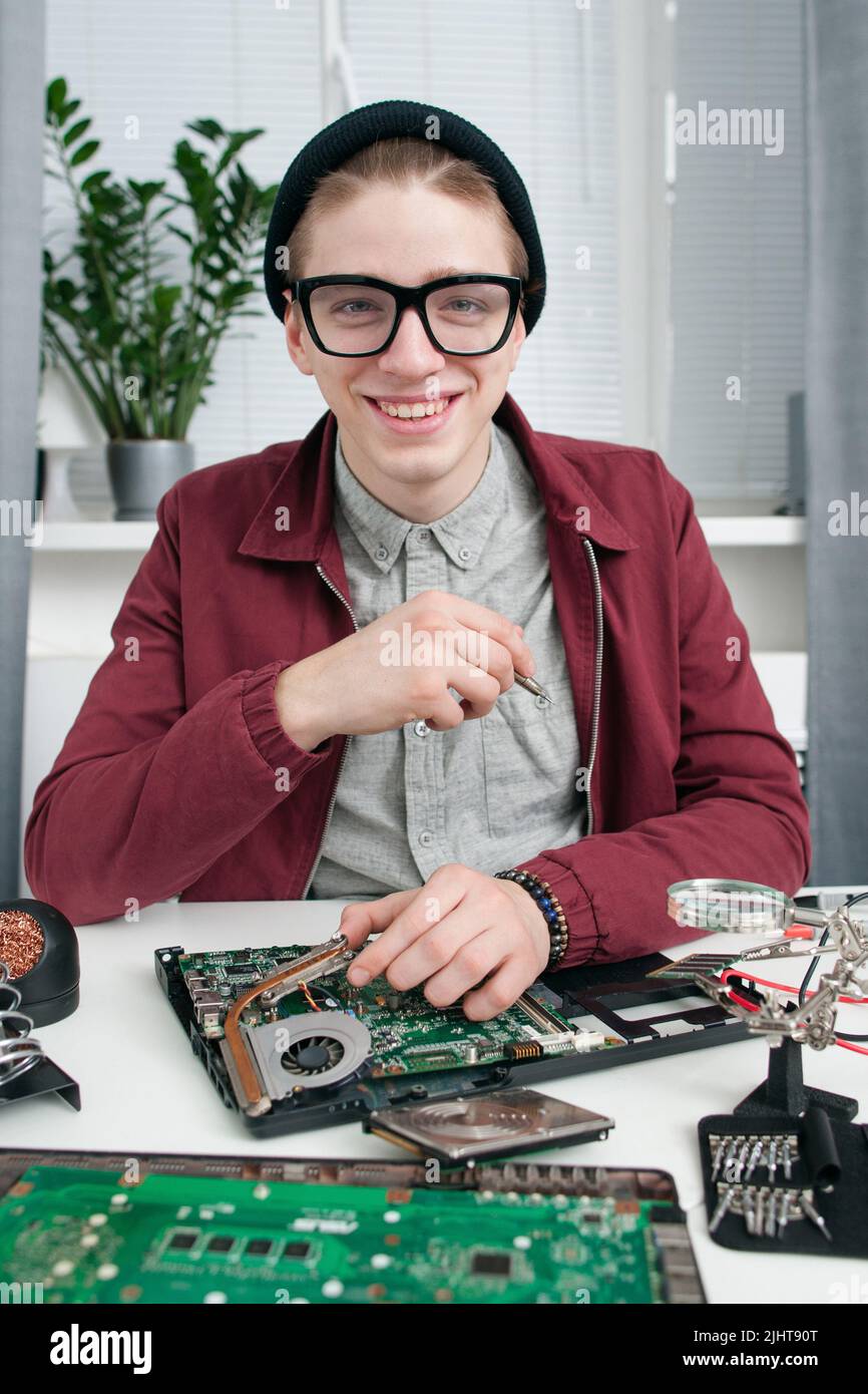 Un réparateur attrayant en lunettes souriant à l'appareil photo Banque D'Images