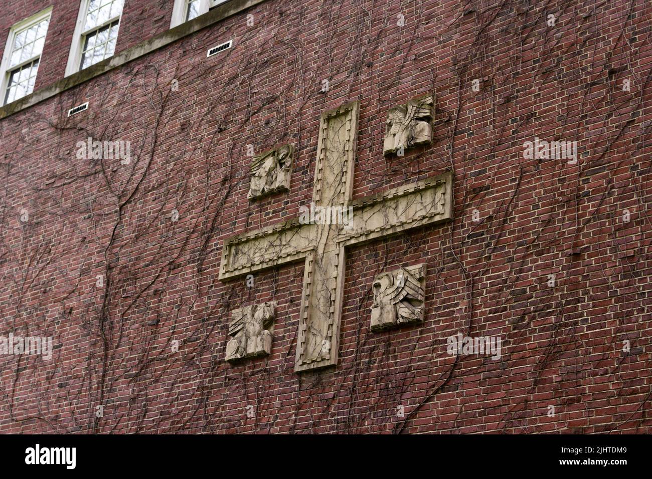 Mur médiéval en brique rouge avec croix de ciment. Les branches se branle au-dessus du mur. Banque D'Images