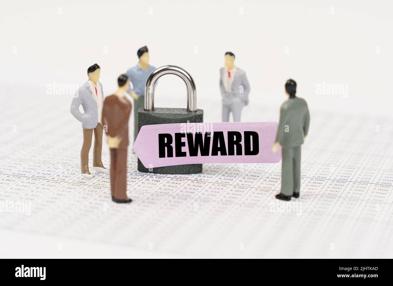Le concept de sécurité dans l'entreprise. Il y a des chiffres de personnes sur les rapports d'affaires, un cadenas avec un autocollant sur lequel il est écrit - récompense Banque D'Images