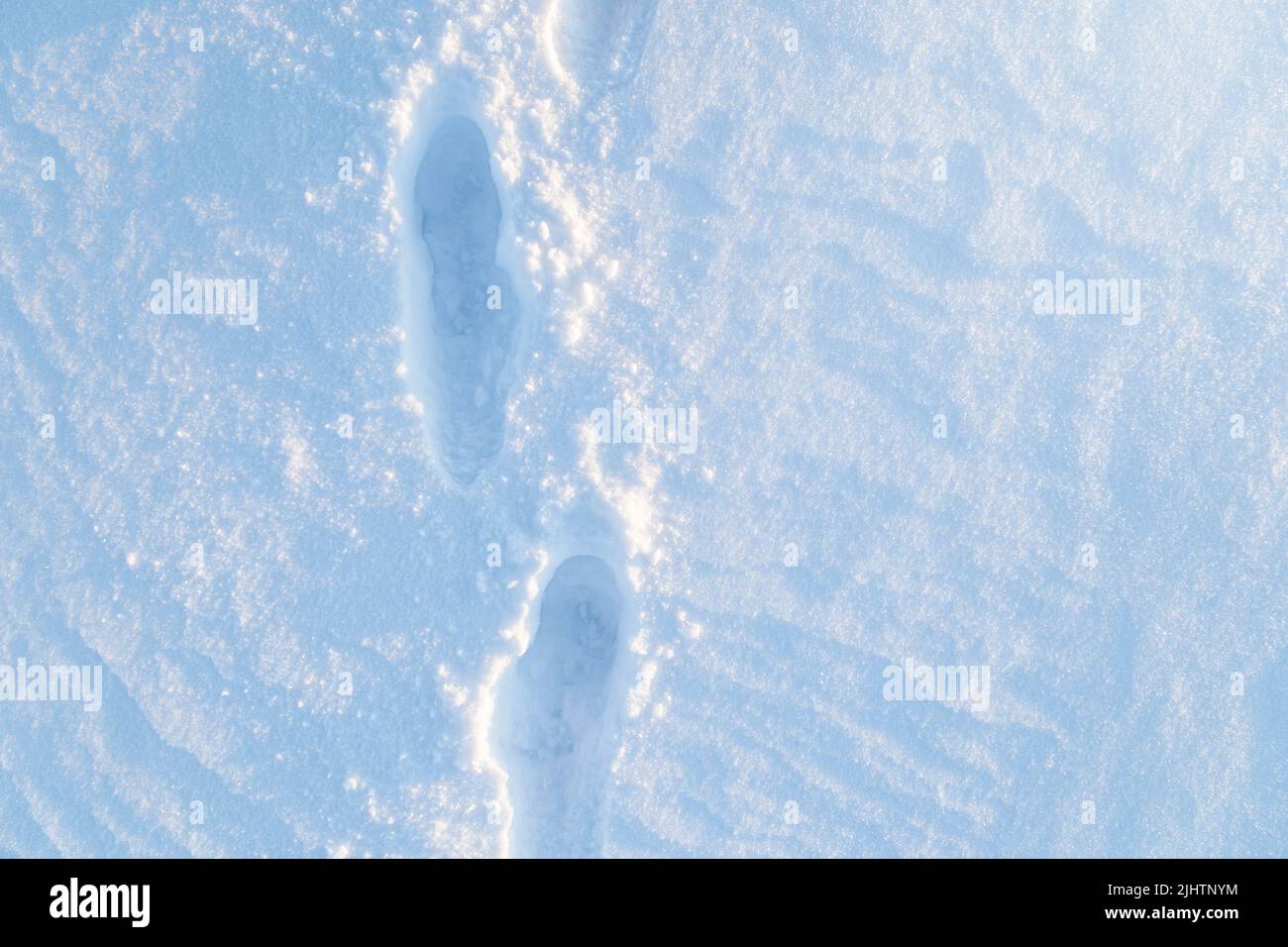 Terrain frais et enneigé avec des traces sur une journée ensoleillée en hiver, vue d'en haut. Banque D'Images