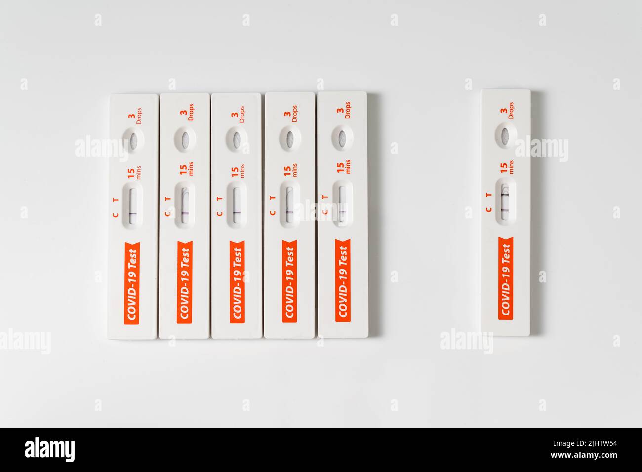 La rangée de kits de test rapide de l'antigène pour le covid-19 et un est positif. Banque D'Images