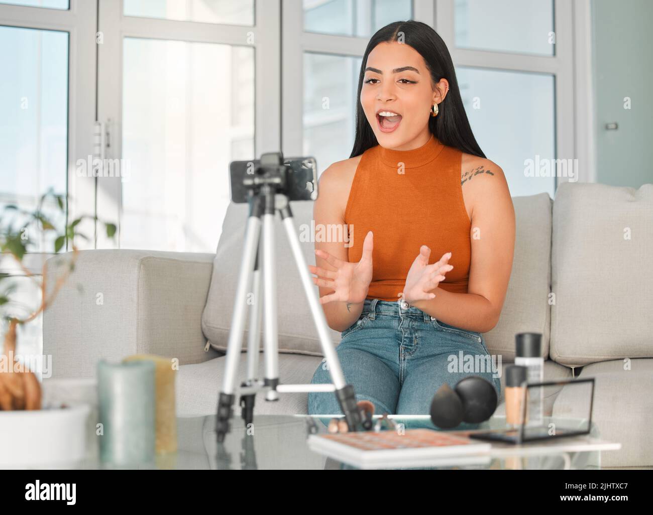 Son vlog de beauté prend son envolante. Une jeune influenceur de beauté attirante en direct de son salon à la maison. Banque D'Images