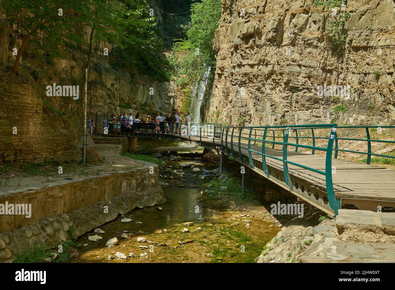 La chute d'eau de Leghvtakhevi et la source naturelle dans le quartier d'Abanotubani , vieux Tbilissi, Géorgie vue de jour avec les touristes marchant Banque D'Images