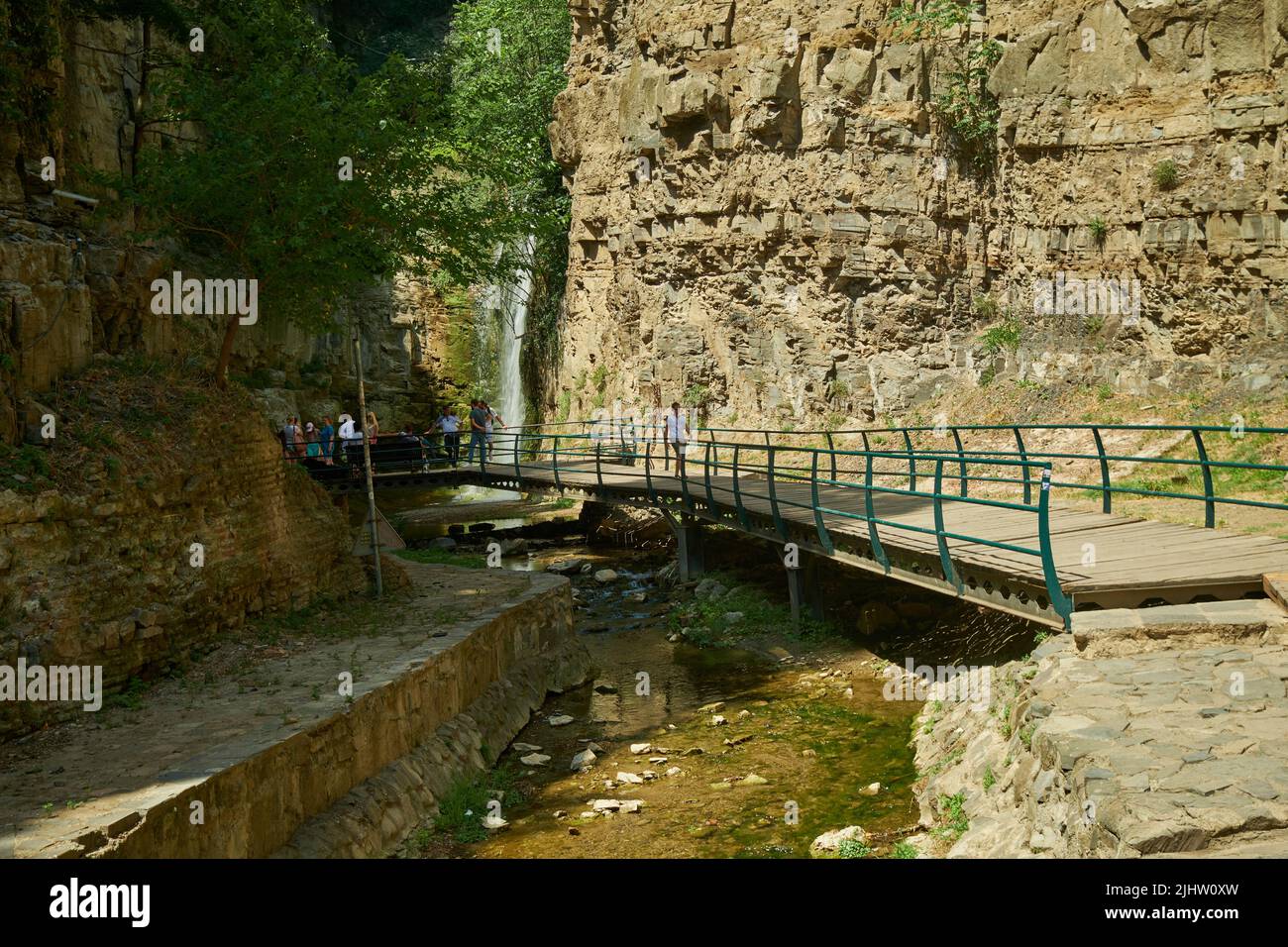 La chute d'eau de Leghvtakhevi et la source naturelle dans le quartier d'Abanotubani , vieux Tbilissi, Géorgie vue de jour avec les touristes marchant Banque D'Images