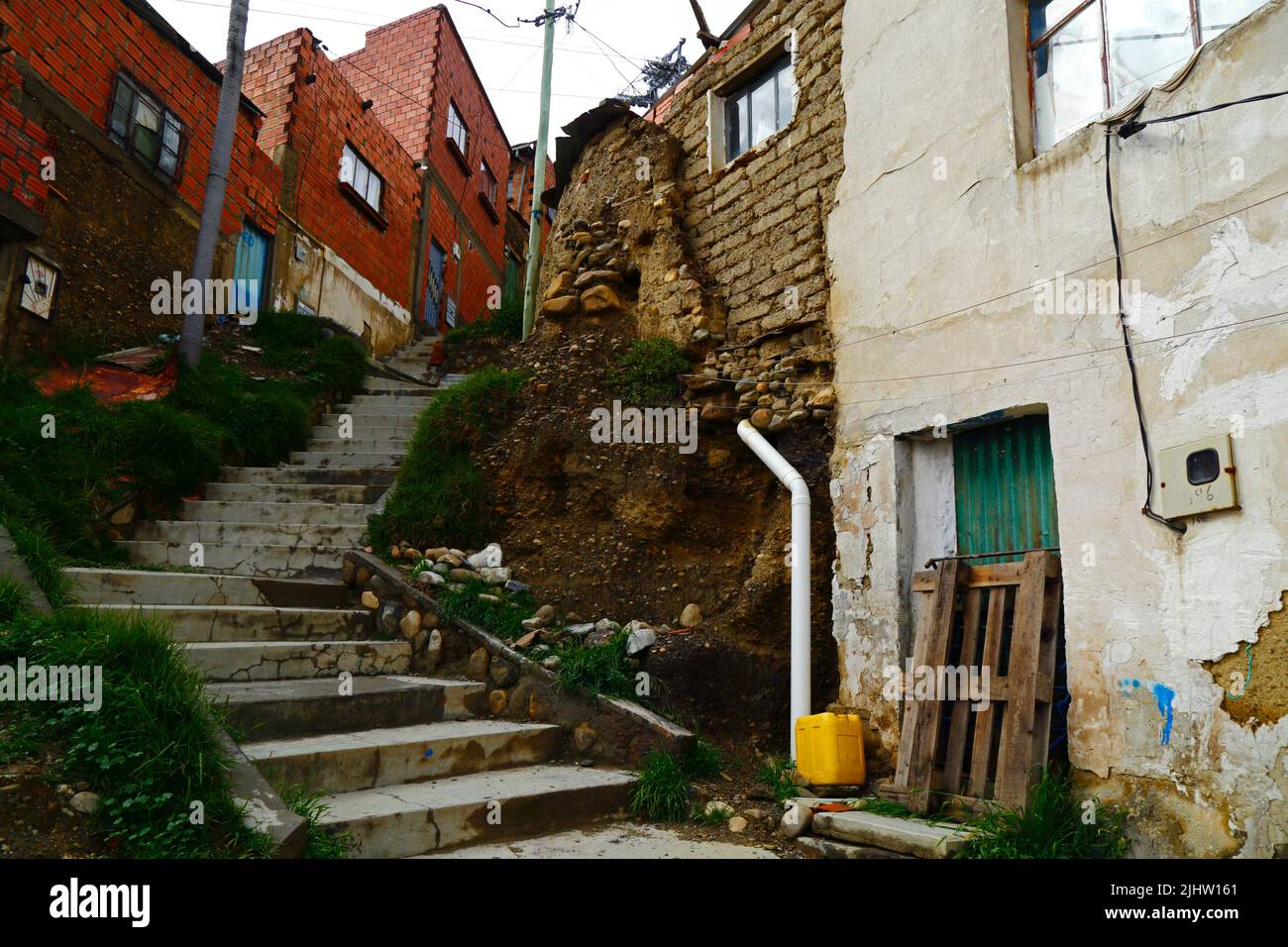 La Paz, Bolivie: Une maison en adobe / mudbrick mal construite avec un système de drainage dangereux causant la filtration de l'eau et l'érosion des sols des fondations dans le district de Tembladerani / Cotahuma. De nombreux quartiers de la Paz à flanc de colline ont été construits dans des zones instables sans permis ou contrôles de construction appropriés. La subsidence et l'érosion causant des glissements de terrain et des maisons à s'effondrer sont courantes, en particulier pendant la saison des pluies. Banque D'Images