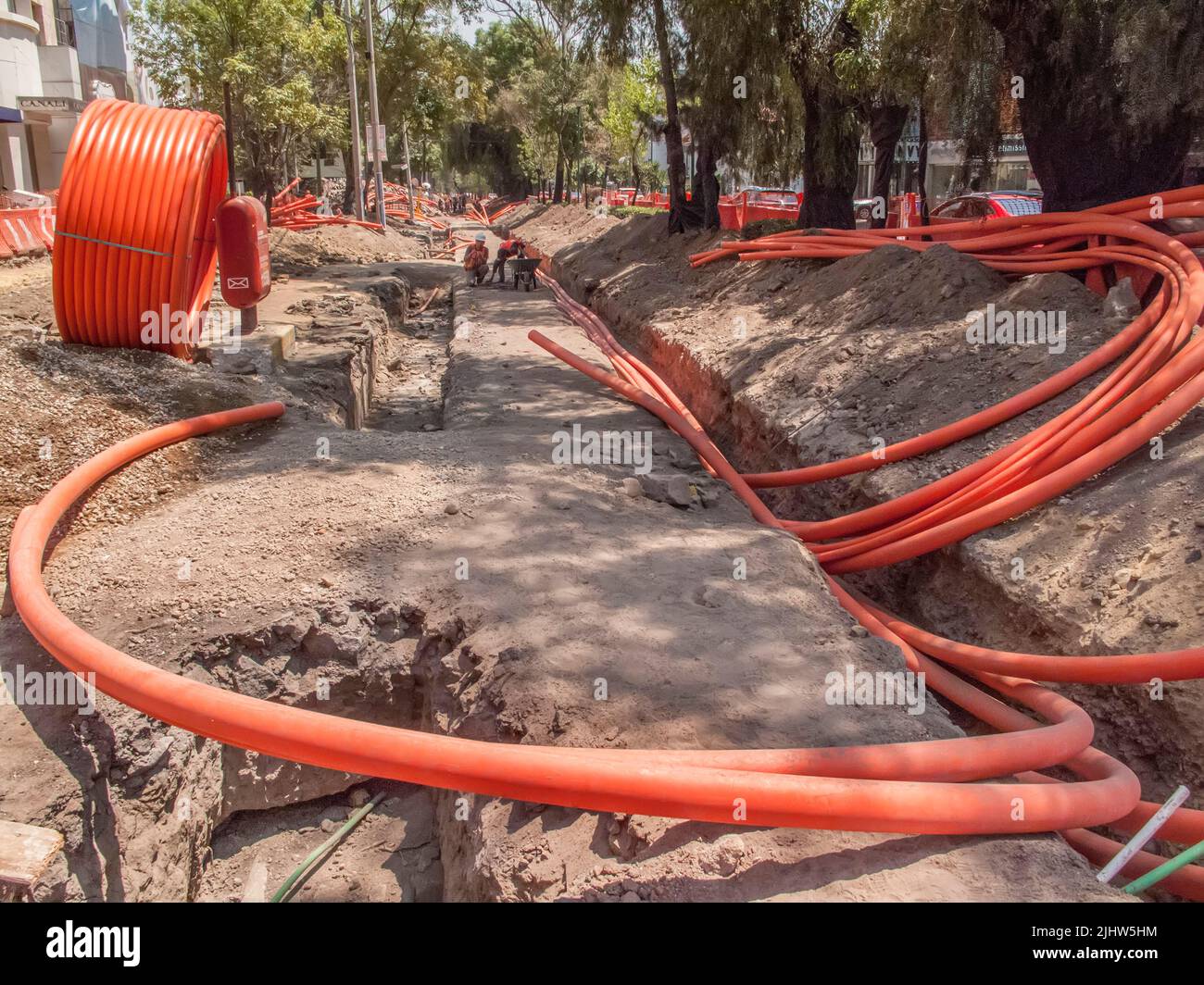 Les travailleurs qui pond des tuyaux souterrains pour transporter des lignes téléphoniques et Internet Banque D'Images