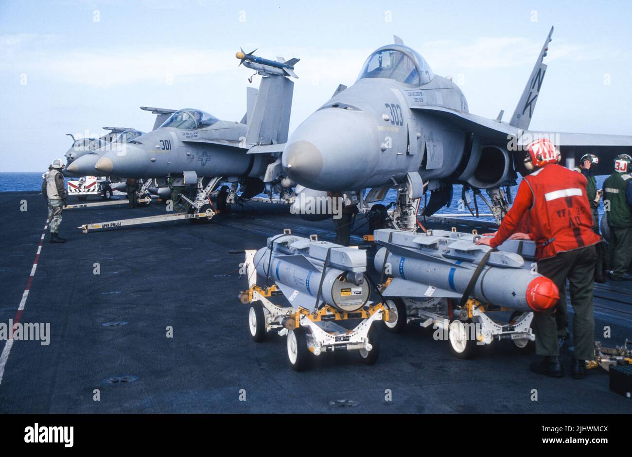 Les armes en début de matinée se chargent avant les opérations de vol alors qu'elles sont en cours en mer Banque D'Images